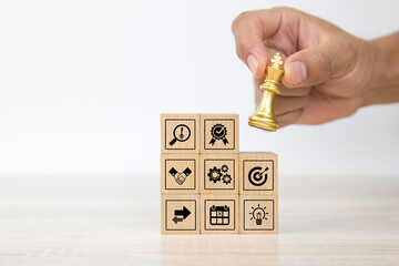 Hand choose cube wooden block stack with king chess on business strategy icon with graph and arrow bullseye of strategic plan and marketing organization management for growth concepts.