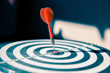 Bullseye or Bulls eye target or dartboard has dart arrow throw hitting the center of a shooting for...