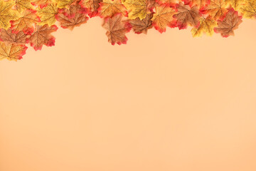 Naklejka na ściany i meble Autumn maple leaf frame top view on orange peach color background.fall backdrop for display of content