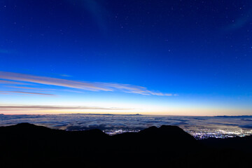 燕山荘展望台から望む明け方の星空と雲の下に見える街の灯り