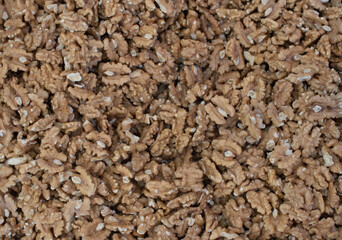 A close-up view of shelled walnut halves, showcasing their rich brown color and intricate texture. The natural patterns and slightly rough surface highlight the freshness.