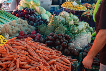 A vibrant farmers' market stall displaying fresh carrots, beets, and cabbages. The colorful array of vegetables highlights the freshness and variety available at local markets.