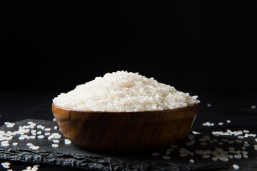 Fototapeta na wymiar Rice in a bowl on black background