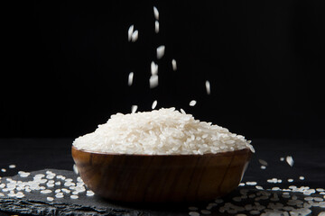 Rice falling in a bowl on black background