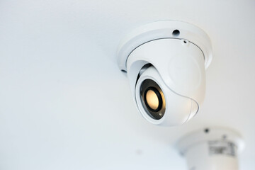 CCTV security camera on white ceiling, operating inside the building with copy space. concept of safety control, crime protect.