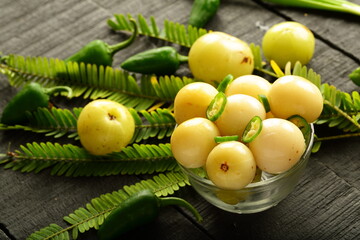 Homemade traditional wild gooseberry pickle  with herbs and spices, Kerala foods background.