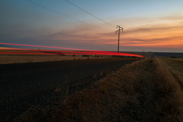 Phantom taillights streaking along a road at dusk, rural Idaho, USA