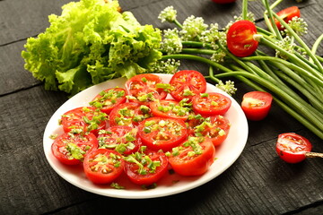 Plate of delicious homemade organic tomato salad. with fresh herbs and greens.