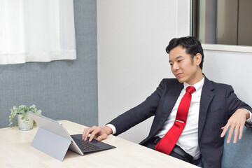 A young Asian man during telework at home loses his motivation at work and works lazily