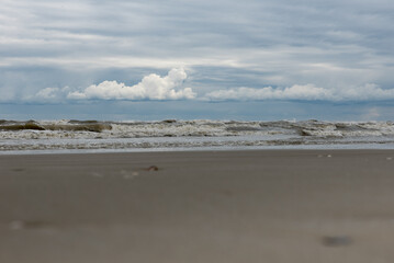 Fototapeta na wymiar Winter seashore with clouds and waves
