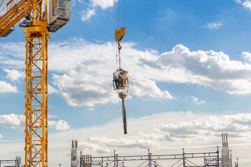 Working at height equipment with bucket liquid concrete container. Construction worker working on a...
