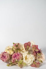 flower composition of roses and hydrangea flowers closeup on a white background. wedding day greeting card. Vertical photo and copy space.