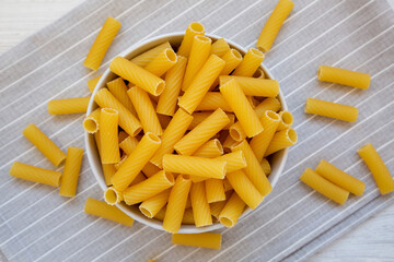 Dry Rigatoni Pasta in a gray Bowl, side view. Copy space.