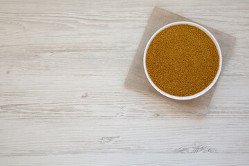 Organic Brown Sugar in a White Bowl on a white wooden background, top view. Flat lay, overhead,...