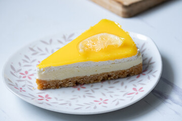 Triangular lemon cheesecake on gray marble background