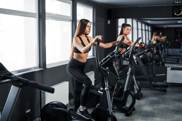 Fototapeta na wymiar Attractive young sports woman is working out in gym. Doing cardio training on treadmill. Running on treadmill.