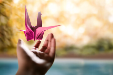 Freedom, Imagination,Mental Health and Creativity Concept. Paper Origami Bird Levitating over an...