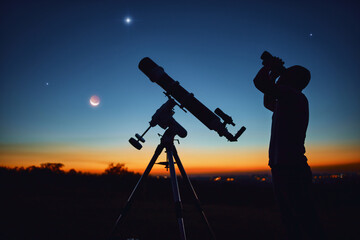 Silhouette of a man, telescope and countryside under the starry skies.