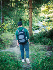 A man with backpack walks in the  autumn forest.