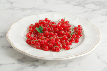 composition of ripe red currant berries on a textured marble background