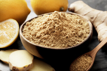 A bowl full of dry ginger on a dark background with lemons and fresh ginger.