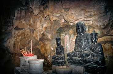 Eingescanntes Diapositiv einer historischen Farbaufnahme in einer Höhle mit Buddhafiguren in einem...