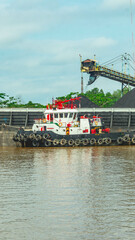 Fototapeta premium Barge full of black coal cruising on Mahakam River, Borneo, Indonesia. Mining and energy