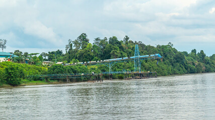Huge conveyor at Mahakam Riverbank used to load coal to the barge. Industrial and mining background
