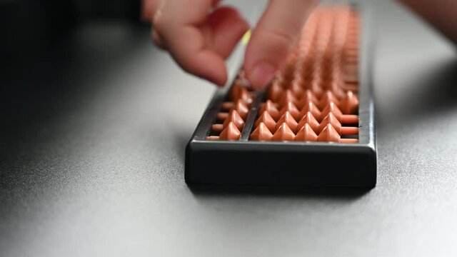 A student is doing calculation manually using abacus calculator.