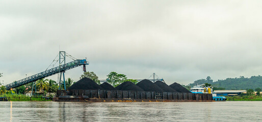 Barge of coal loaded by conveyor, Mahakam River, Outback of Borneo, Indonesia