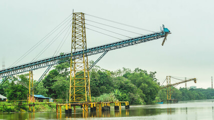 Huge conveyor at Mahakam Riverbank used to load coal to the barge. Industrial and mining background