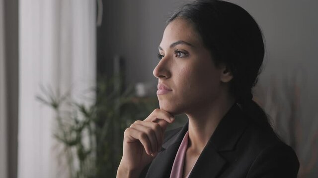 young business woman thinking future plan new idea looking out the window,side view portrait of pensive arab latina female look for inspiration