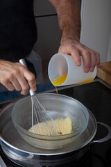 Chef cocinando al baño María con varilla en cocina. Chef cooking in a bain-marie with a rod in the kitchen.