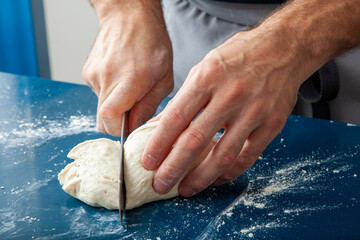 Manos de chef cortando masa de pizza. 
Chef hands cutting pizza dough - Powered by Adobe