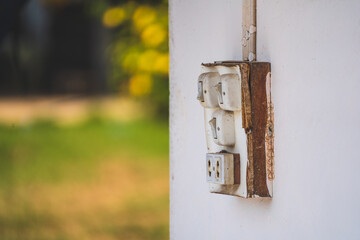 Old white switches and power socket on white wall. 