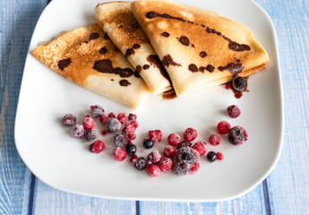 Homemade pancakes with berries. Lie on a white plate.