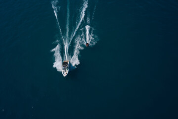 Boat and water scooter parallel movement on the water aerial view. Race on the water. Travel -...