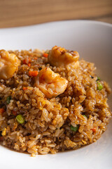 Sautéed rice with prawns and vegetables. Served on a white porcelain plate. Macro perspective. restaurant. Menu