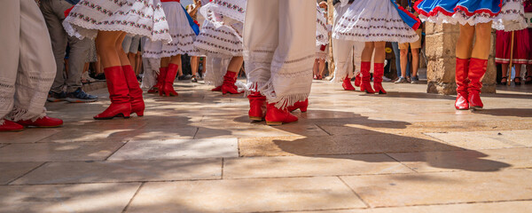 Dancers in Ukrainian colorful folk costumes at Montblanc folk festival in Spain, view with the red...
