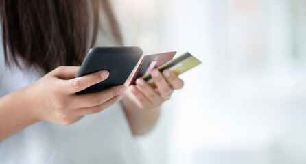 Focus on hand young asian woman holding mobile phone and using mobile app to shopping or paying online