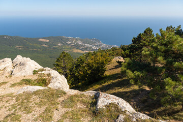 Rocky landscape of Crimea - mountain view of a small tourist town surrounded by trees and greenery on a summer day