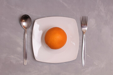 Ripe bananas and orange on a wooden table