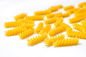 Raw Fusilli pasta, isolated on white background, selective focus. Italian pasta