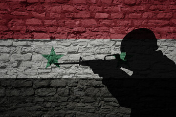 Soldier silhouette on the old brick wall with flag of syria country.