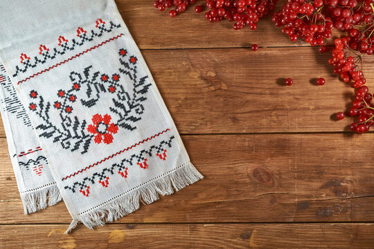 Ukrainian still life with traditional elements: flag of Ukraine, national embroidery and viburnum berries on a wooden background