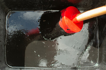 Brush in black paint. Brush in a container with waterproof paint.