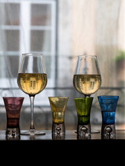 two glasses of wine and three shot glasses 