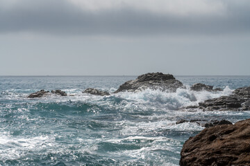 waves crashing on rocks in evening cloudy weather