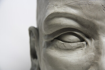 Close-up clay eye, detail of female face sculpture on white background