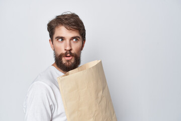 bearded man with craft package in hands shopping emotions light background